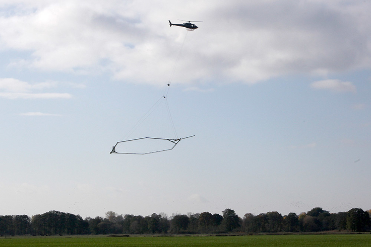 Bei SkyTEM-Befliegungen schleppt ein Hubschrauber in rund 30 Metern Höhe eine Antenne über die Geländeoberfläche.