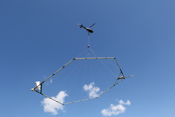 Der Hubschrauber zieht bei den Messungen in circa 30 Meter Höhe eine Antenne über das Gelände, um die geologischen Verhältnisse im Untergrund (zum Beispiel Grundwasservorkommen) zu ermitteln.