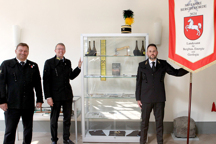 LBEG-Präsident Carsten Mühlenmeier (M.), Jubiläums-Cheforganisator Stefan Wittke (li.) und LBEG-Traditionsbeauftragter Jens Knochen präsentieren die kleine Ausstellung zur Erinnerung an die Feier „500 Jahre Bergbehörde“.