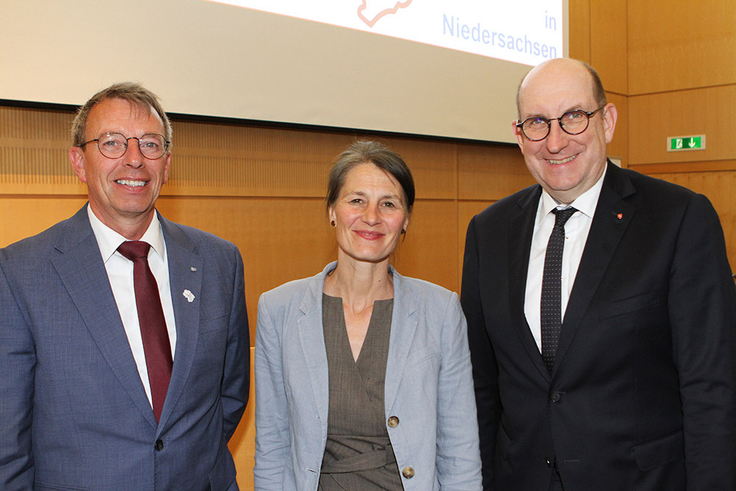 Niedersachsens Landwirtschaftsministerin Miriam Staudte (M.) und Wirtschaftsstaatssekretär Matthias Wunderling-Weilbier (re.) gratulieren LBEG-Präsidenten Carsten Mühlenmeier zu 75 Jahre Staatlicher Geologischer Dienst und 40 Jahre NIBIS.