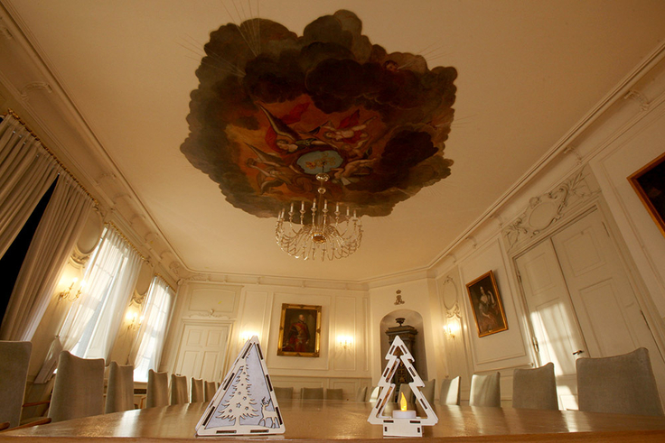 Das Bild zeigt den Weißen Saal mit weihnachtlichem Schmuck im Vordergrund.