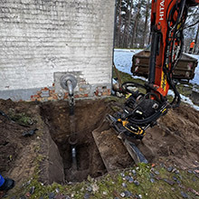 Das Bild zeigt die ausgehobene Grube und die freigelegte Leitung